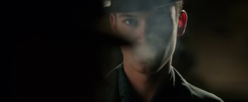 Movie still from “Predestination” (2014), directed by Michael Spierig – A person wearing a hat with smoke coming out; Close Up shot, Over the shoulder angle