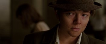 Movie still from “Predestination” (2014), directed by Michael Spierig – A person wearing a hat; Close Up shot, Over the shoulder angle