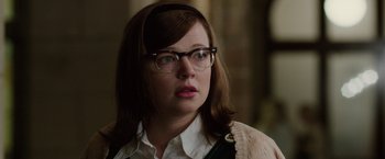 Movie still from “Predestination” (2014), directed by Michael Spierig – A person wearing glasses and looking at the camera; Close Up shot, Over the shoulder angle