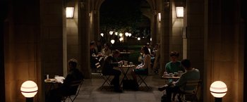 Movie still from “Predestination” (2014), directed by Michael Spierig – A group of people sitting at a table in a building; Extreme Wide shot, High angle