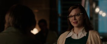 Movie still from “Predestination” (2014), directed by Michael Spierig – A woman wearing glasses standing in a room; Close Up shot, Over the shoulder angle