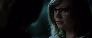 Movie still from “Predestination” (2014), directed by Michael Spierig – A person wearing glasses and looking at the camera; Close Up shot, Over the shoulder angle