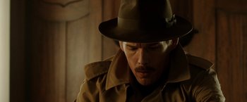 Movie still from “Predestination” (2014), directed by Michael Spierig – A person wearing a hat; Close Up shot, Over the shoulder angle