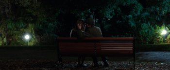 Movie still from “Predestination” (2014), directed by Michael Spierig – A man and a woman sitting on top of a wooden bench; Wide shot, High angle