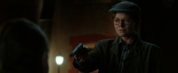 Movie still from “Predestination” (2014), directed by Michael Spierig – A person holding a gun in a dark room; Close Up shot, Over the shoulder angle