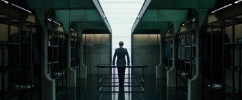 Movie still from “Predestination” (2014), directed by Michael Spierig – A man in a suit standing in front of a train platform; Wide shot, Low angle