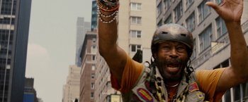 Movie still from “Premium Rush” (2012), directed by David Koepp – A man in a motorcycle helmet is raising his arm; Close Up shot, Low angle