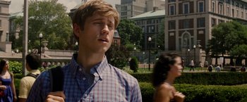 Movie still from “Premium Rush” (2012), directed by David Koepp – A young man in a plaid shirt standing next to a woman; Close Up shot, Over the shoulder angle