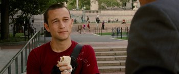 Movie still from “Premium Rush” (2012), directed by David Koepp – A man holding a burrito while standing in front of stairs; Close Up shot, Over the shoulder angle