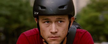 Movie still from “Premium Rush” (2012), directed by David Koepp – A person wearing a helmet; Close Up shot, High angle