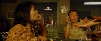 Movie still from “Premium Rush” (2012), directed by David Koepp – Two people are sitting at a table and one of them is talking on the phone; Close Up shot, Over the shoulder angle