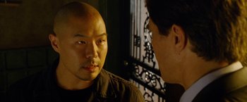 Movie still from “Premium Rush” (2012), directed by David Koepp – Two men are facing each other in front of an iron gate; Close Up shot, Over the shoulder angle