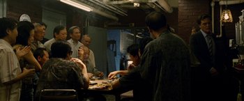 Movie still from “Premium Rush” (2012), directed by David Koepp – A group of people sitting at a table eating food; Medium shot, High angle