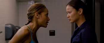 Movie still from “Premium Rush” (2012), directed by David Koepp – Two women are facing each other in front of a wall; Close Up shot, Over the shoulder angle