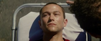 Movie still from “Premium Rush” (2012), directed by David Koepp – A young man is laying down on a bed; Close Up shot, Overhead angle