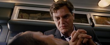 Movie still from “Premium Rush” (2012), directed by David Koepp – A man in a suit and tie on a train; Close Up shot, Over the shoulder angle