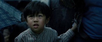 Movie still from “Premium Rush” (2012), directed by David Koepp – A young boy in a striped shirt looking up at the sky; Close Up shot, Low angle