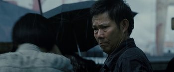 Movie still from “Premium Rush” (2012), directed by David Koepp – A person holding an open umbrella; Close Up shot, Low angle