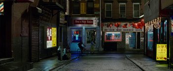 Movie still from “Premium Rush” (2012), directed by David Koepp – A person riding a bike down a street at night; Extreme Wide shot, High angle