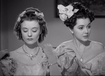 Movie still from “Pride and Prejudice” (1940), directed by Robert Z. Leonard – Two young women in old - fashioned dresses with bows on their heads; Close Up shot, Low angle
