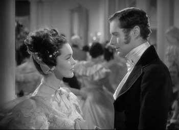 Movie still from “Pride and Prejudice” (1940), directed by Robert Z. Leonard – A man and a woman standing next to each other; Medium shot, Over the shoulder angle