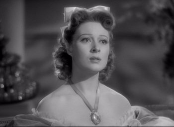 Movie still from “Pride and Prejudice” (1940), directed by Robert Z. Leonard – A black and white photo of a woman with a bow in her hair; Close Up shot, Low angle