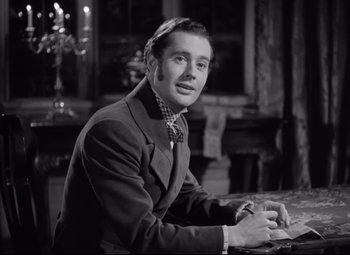 Movie still from “Pride and Prejudice” (1940), directed by Robert Z. Leonard – A black and white photo of a man writing; Medium shot, Over the shoulder angle