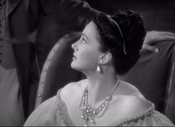 Movie still from “Pride and Prejudice” (1940), directed by Robert Z. Leonard – An old photo of a woman wearing a necklace and pearls; Close Up shot, High angle