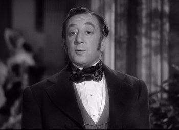 Movie still from “Pride and Prejudice” (1940), directed by Robert Z. Leonard – An older man in a suit and bow tie; Close Up shot, Low angle
