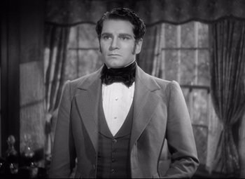 Movie still from “Pride and Prejudice” (1940), directed by Robert Z. Leonard – A black and white photo of a man in a suit; Close Up shot, Over the shoulder angle