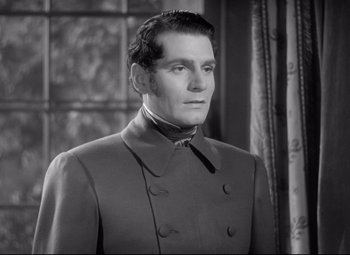 Movie still from “Pride and Prejudice” (1940), directed by Robert Z. Leonard – A black and white photo of a man in a suit; Close Up shot, Over the shoulder angle