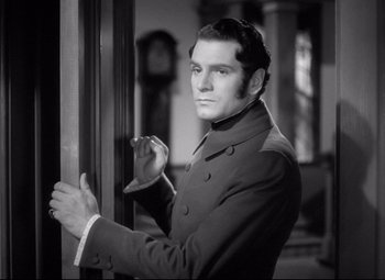 Movie still from “Pride and Prejudice” (1940), directed by Robert Z. Leonard – A black and white photo of a man in a suit; Close Up shot, Over the shoulder angle