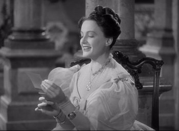 Movie still from “Pride and Prejudice” (1940), directed by Robert Z. Leonard – An old photo of a woman reading a piece of paper; Medium shot, Over the shoulder angle
