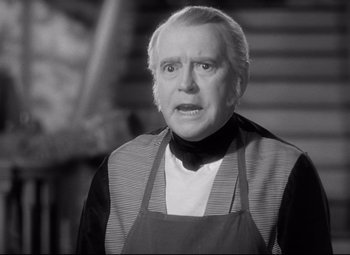Movie still from “Pride and Prejudice” (1940), directed by Robert Z. Leonard – An older man wearing an apron looking surprised; Close Up shot, Over the shoulder angle
