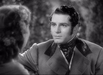 Movie still from “Pride and Prejudice” (1940), directed by Robert Z. Leonard – A man wearing a suit and tie and a woman wearing a hat; Close Up shot, Over the shoulder angle