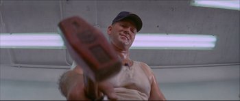 Movie still from “Prime Cut” (1972), directed by Michael Ritchie – A man in a baseball cap holding a baseball bat in his hand; Close Up shot, Low angle