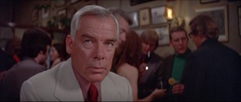 Movie still from “Prime Cut” (1972), directed by Michael Ritchie – An older man in a white suit and a red tie; Close Up shot, Over the shoulder angle