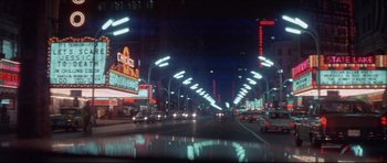 Movie still from “Prime Cut” (1972), directed by Michael Ritchie – A city street at night lit up by street lights; Extreme Wide shot, High angle