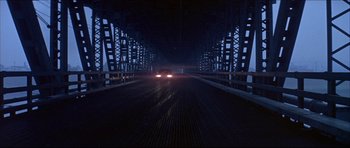 Movie still from “Prime Cut” (1972), directed by Michael Ritchie – A car is driving on a bridge at night; Extreme Wide shot, Low angle
