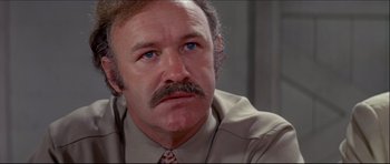 Movie still from “Prime Cut” (1972), directed by Michael Ritchie – An older man wearing a tie and a brown shirt; Close Up shot, Low angle