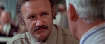 Movie still from “Prime Cut” (1972), directed by Michael Ritchie – An older man wearing a tie and a jacket; Close Up shot, Over the shoulder angle