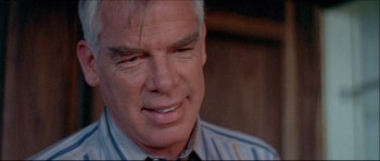 Movie still from “Prime Cut” (1972), directed by Michael Ritchie – An older man with a goatee looking at the camera; Close Up shot, Over the shoulder angle