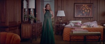Movie still from “Prime Cut” (1972), directed by Michael Ritchie – A woman in a long green dress standing in front of a mirror; Medium shot, Low angle