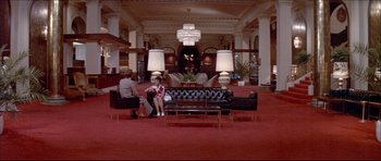 Movie still from “Prime Cut” (1972), directed by Michael Ritchie – Two people sitting on couches in a large room; Extreme Wide shot, High angle