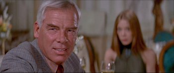 Movie still from “Prime Cut” (1972), directed by Michael Ritchie – An older man sitting at a table with a woman; Close Up shot, Low angle