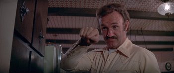 Movie still from “Prime Cut” (1972), directed by Michael Ritchie – A man holding a knife in his hand in front of a mirror; Close Up shot, Low angle