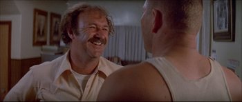 Movie still from “Prime Cut” (1972), directed by Michael Ritchie – Two men talking to each other in front of a window; Close Up shot, Low angle