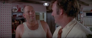 Movie still from “Prime Cut” (1972), directed by Michael Ritchie – Two men talking to each other in front of a mirror; Close Up shot, Over the shoulder angle