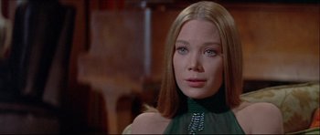 Movie still from “Prime Cut” (1972), directed by Michael Ritchie – A woman with long blonde hair wearing a green top; Close Up shot, Over the shoulder angle