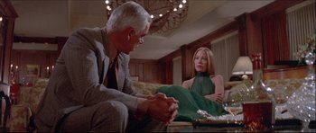 Movie still from “Prime Cut” (1972), directed by Michael Ritchie – A man and a woman sitting on a couch in a room; Medium shot, Over the shoulder angle